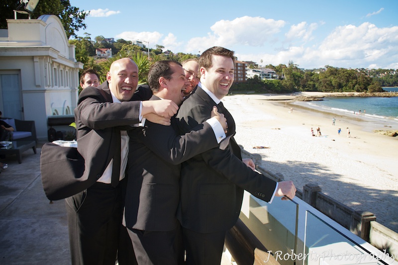 Groomsmen holding groom back from leap before wedding - wedding photography sydney